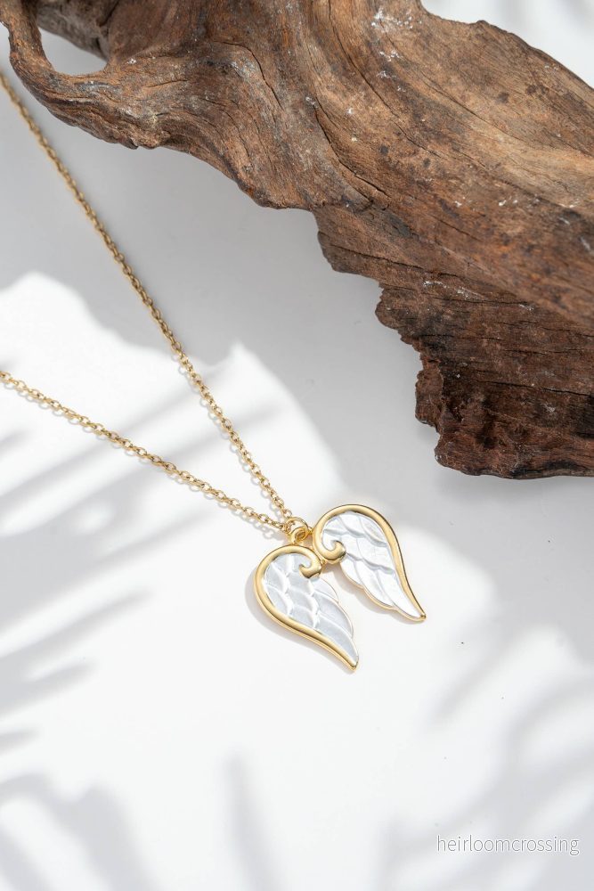 Änglavingar halsband i stål med pärlemorhjärta och himmelsk symbolik Änglavingar halsband i stål med pärlemorhjärta och himmelsk symbolik